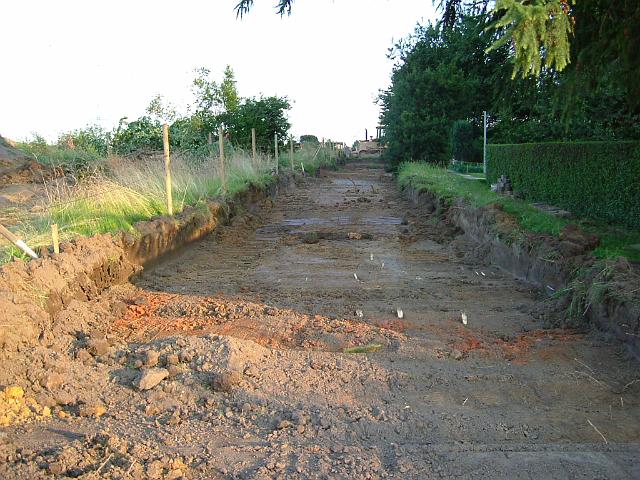 2005_0705_193102.JPG - Fläche für die Süd-Nord-Mulde hinter dem Altbestand Richtung Süden - Der Mutterboden ist abgetragen. Bei der im Vordergrund zu erkennenden Bodenverfärbung handelt es sich um einen archäologischen Fund.