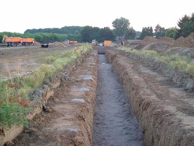 2005_0711_203246.JPG - Große Mulde südl. des Altbestandes Richtung Westen - Rigole ist mit Sand abgedeckt. Die Rigolen-Elemente sind kaskadenförmig angelegt, um den Höhenunterschied auszugleichen. Die Mulden-Rohr-Rigolen-Systeme erzielen die beste Wirksamkeit bei möglichst horizontaler Anordnung.