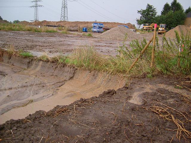 2005_0727_190012.JPG - Fläche für die zukünftige Mulde westl. des Bauträgerbereiches an der Ewald-Görshop-Straße - Blickrichtung: Süd/Ost - Wasser läuft vom Acker auf die zukünftige Muldenfläche.