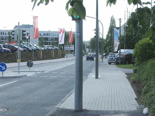 2009_0518_174937.JPG - Ampelanlage an der Zufahrt zum Hellweg-Parkplatz. Hinter der Ampel rechts die Zufahrt zum Parkplatz des Tennisvereins. Es besteht durch die schraffierte Fläche keine Möglichkeit aus Richtung Westen zum Tennisverein, bzw. vom Parkplatz des Tennisvereins nach links Richtung Oespel abzubiegen.